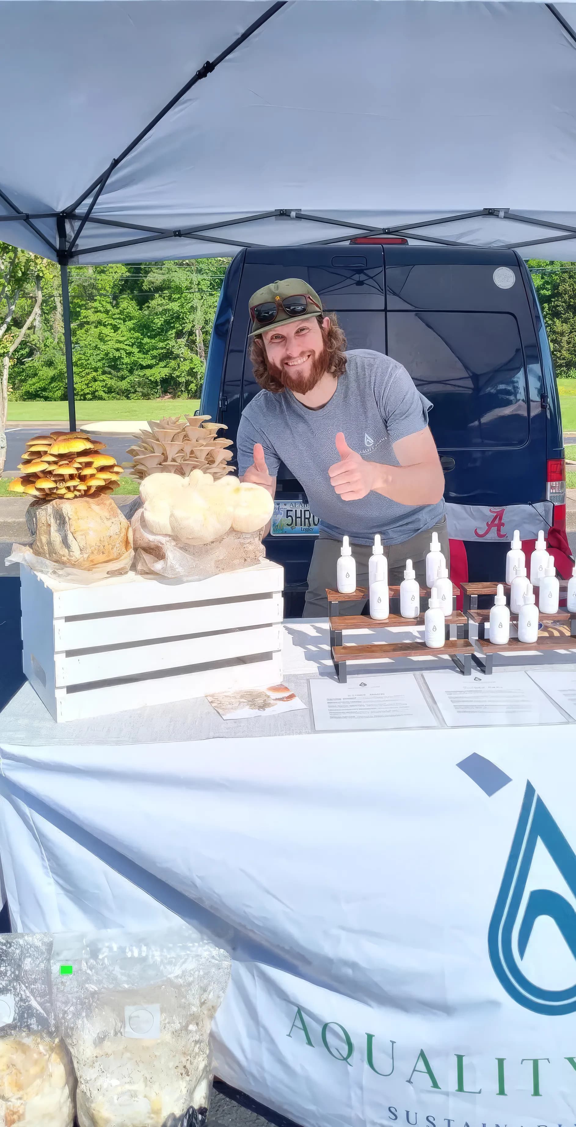 Samuel Sawyer at the farmers market with mushrooms and tinctures at the Aquality Farms booth