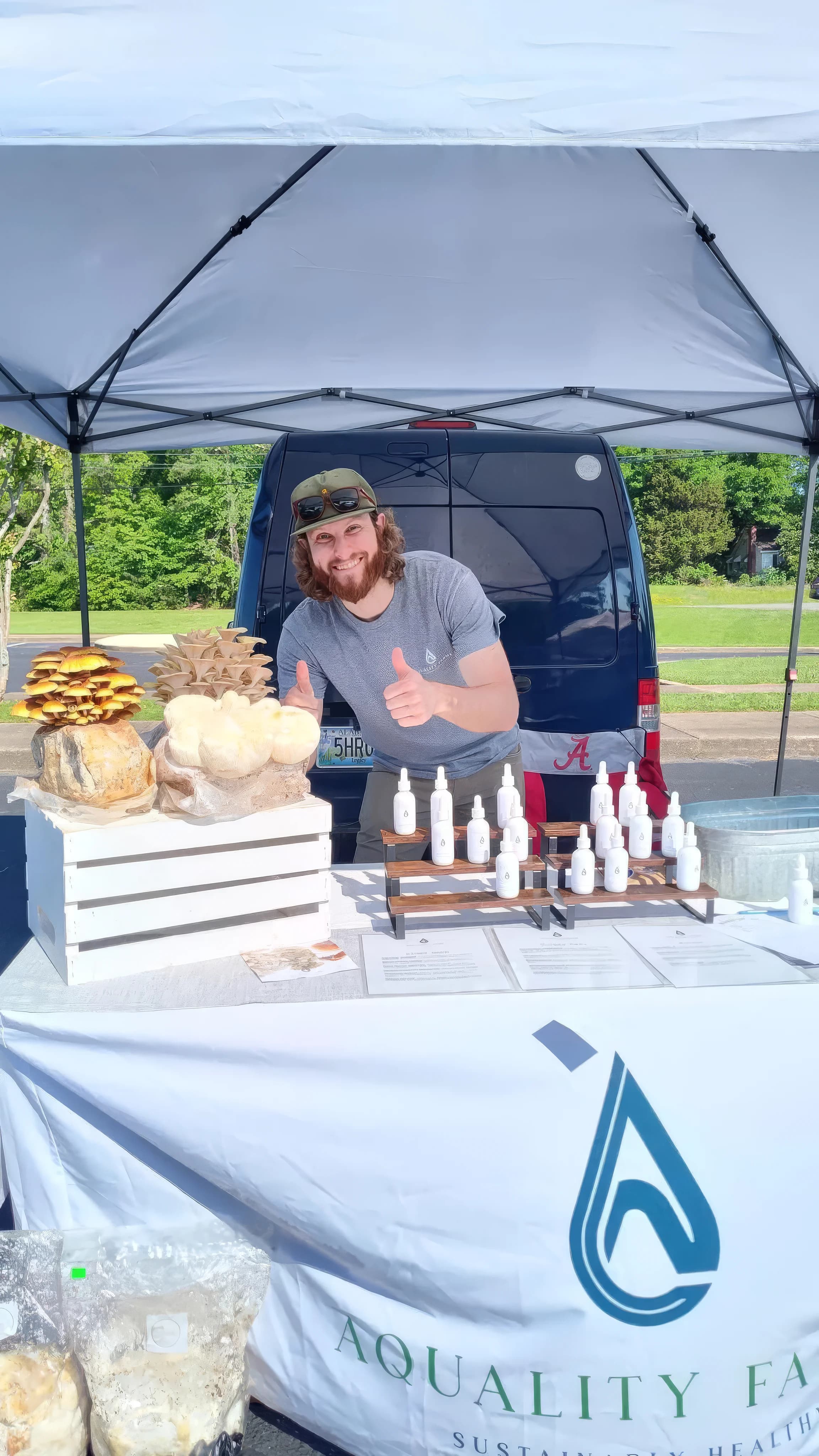 Samuel Sawyer at the farmers market with mushrooms and tinctures at the Aquality Farms booth