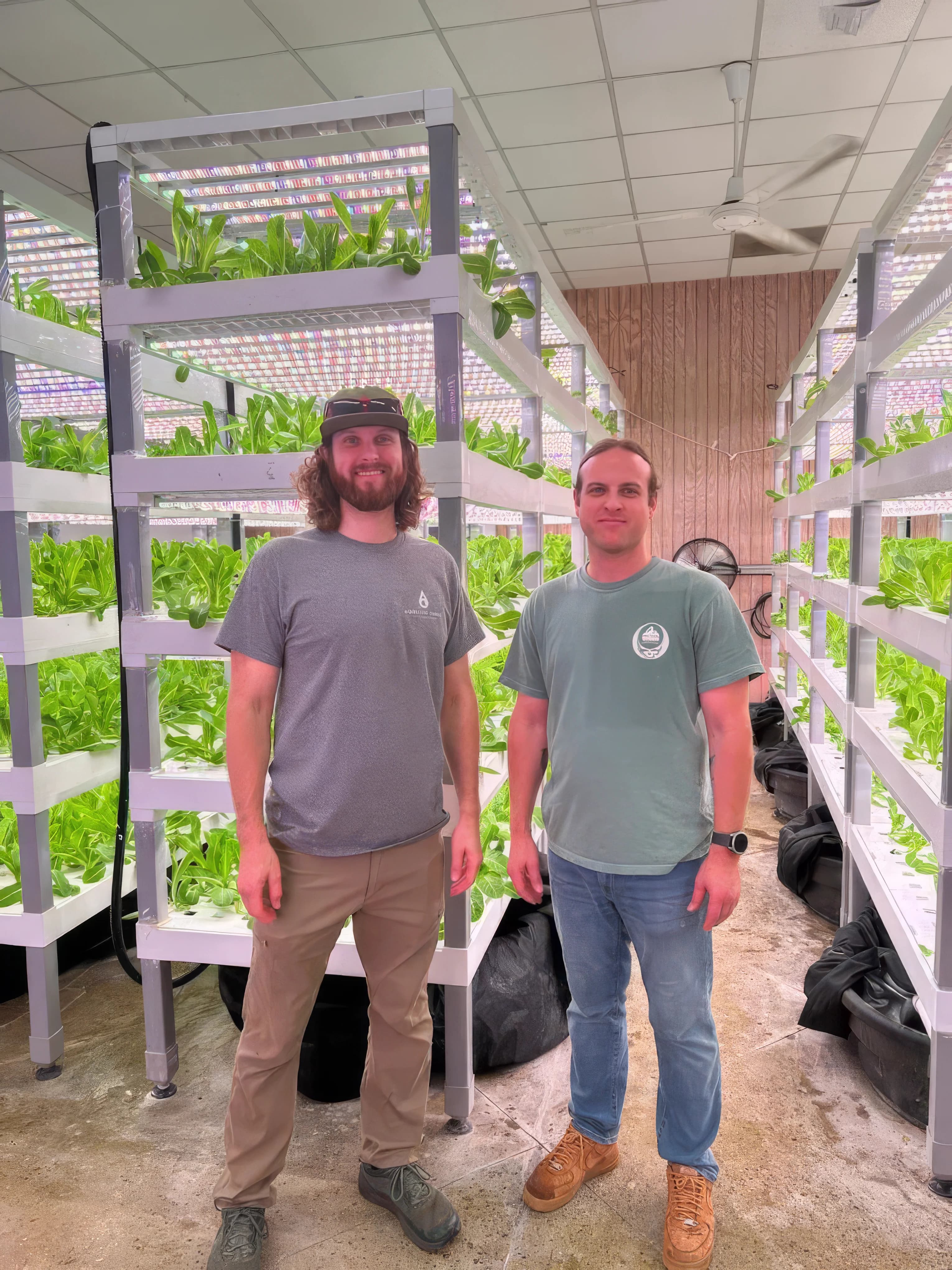 Samuel and John Mark Sawyer standing in the Aquality Farms grow room with vertical lettuce towers