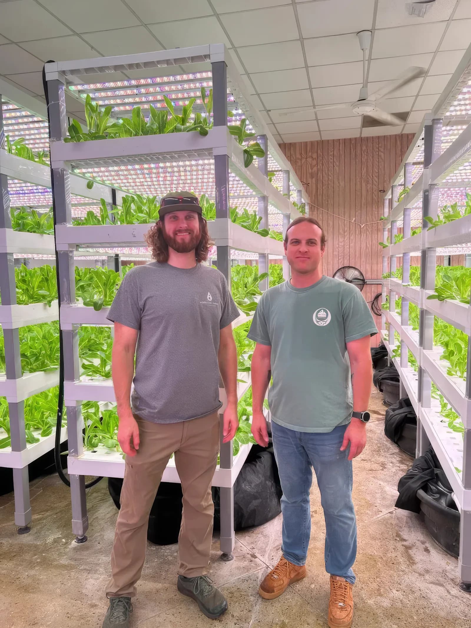 Samuel and John Mark Sawyer standing in the Aquality Farms grow room with vertical lettuce towers