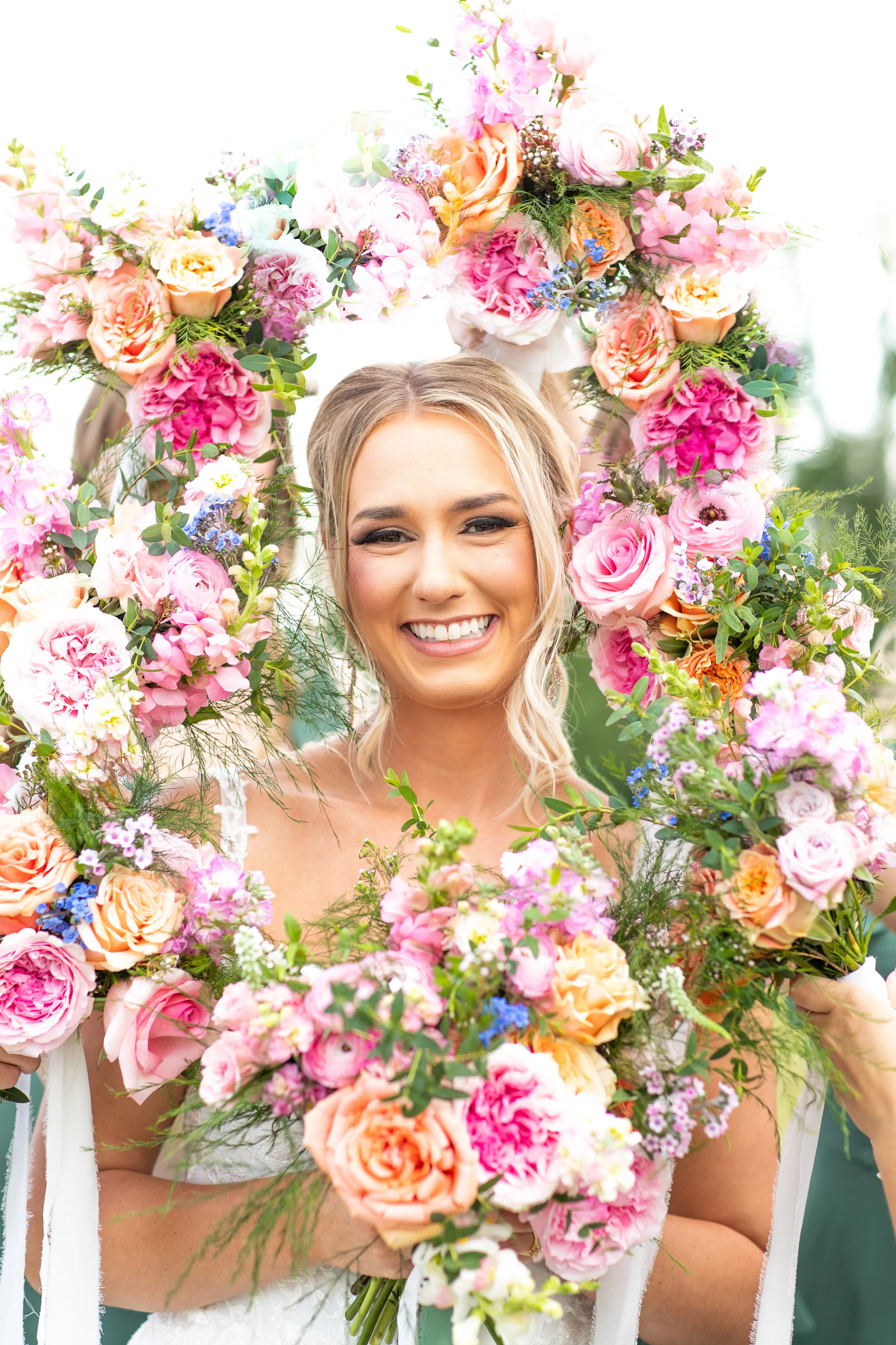 Sonny Jenkins framed in a lush floral wreath of pink, coral, and peach flowers — Heather Headley's first wedding