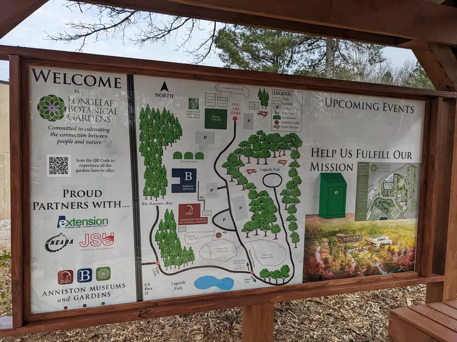 Welcome sign and trail map at the entrance to Longleaf Botanical Gardens