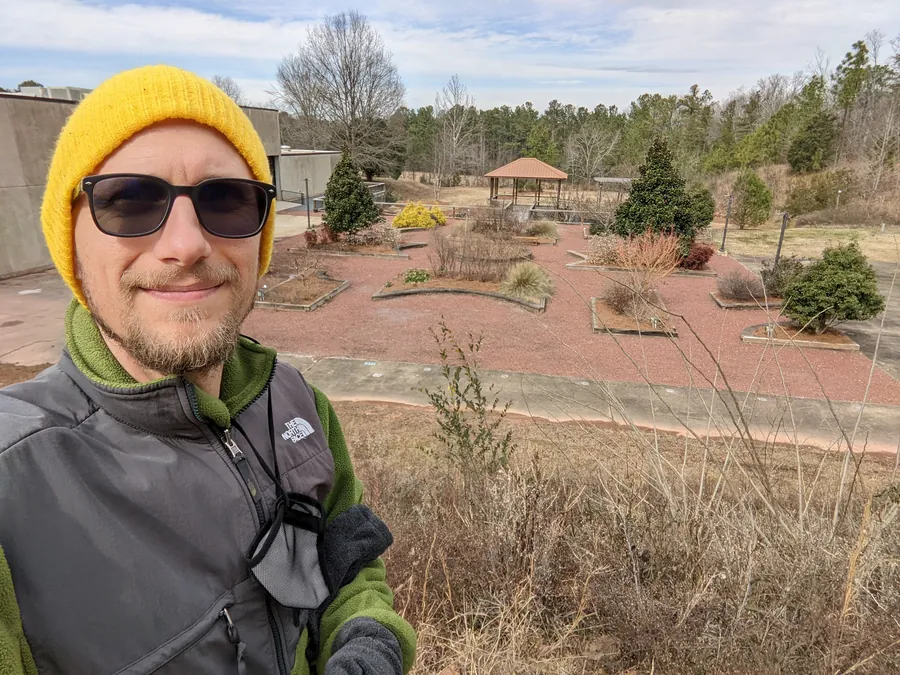 Matt Headley overlooking the raised garden beds and gazebo at Longleaf Botanical Gardens