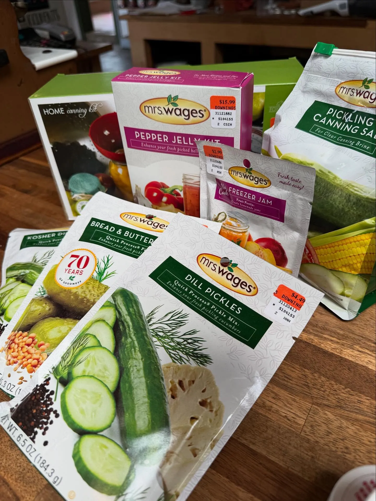Mrs. Wages canning and preserving products spread out on a table at Downing and Sons, including dill pickle mix, bread and butter mix, pepper jelly, and pickling salt