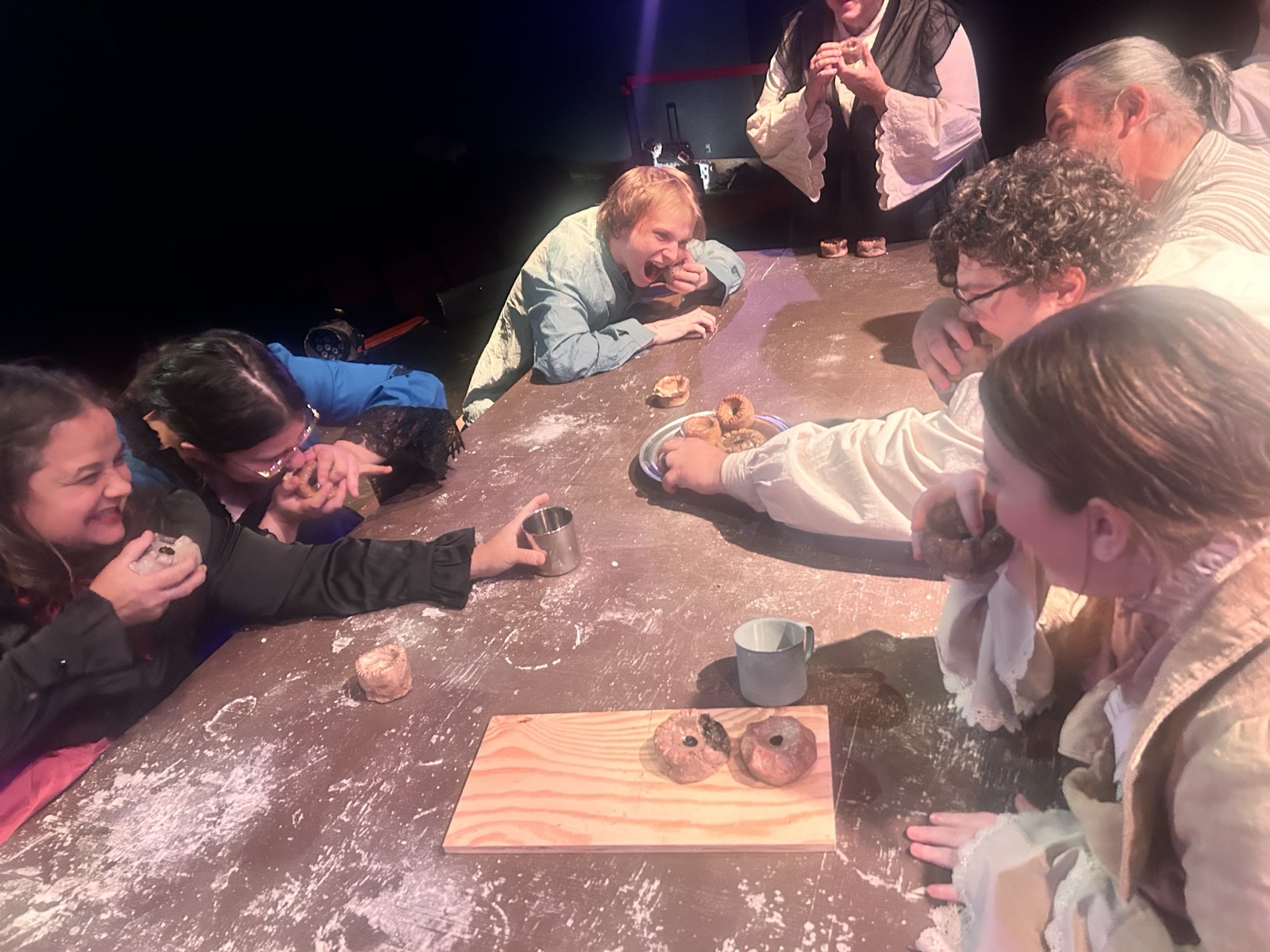 The cast eating meat pies in character